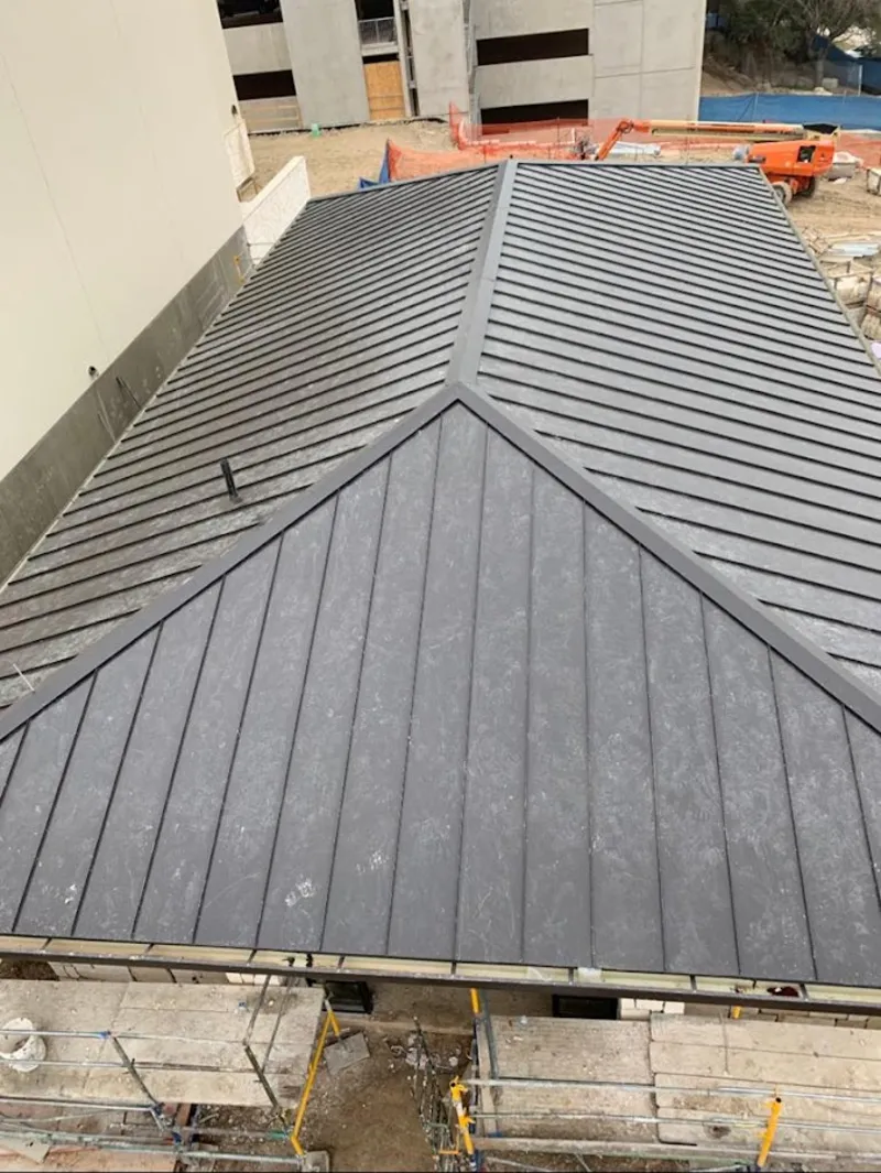 Commercial metal roof construction with crane equipment in Crystal Lake